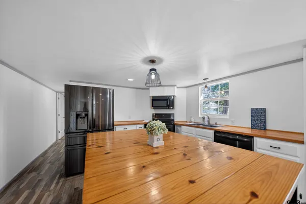 a view of a kitchen counter space a sink wooden floor and living room view