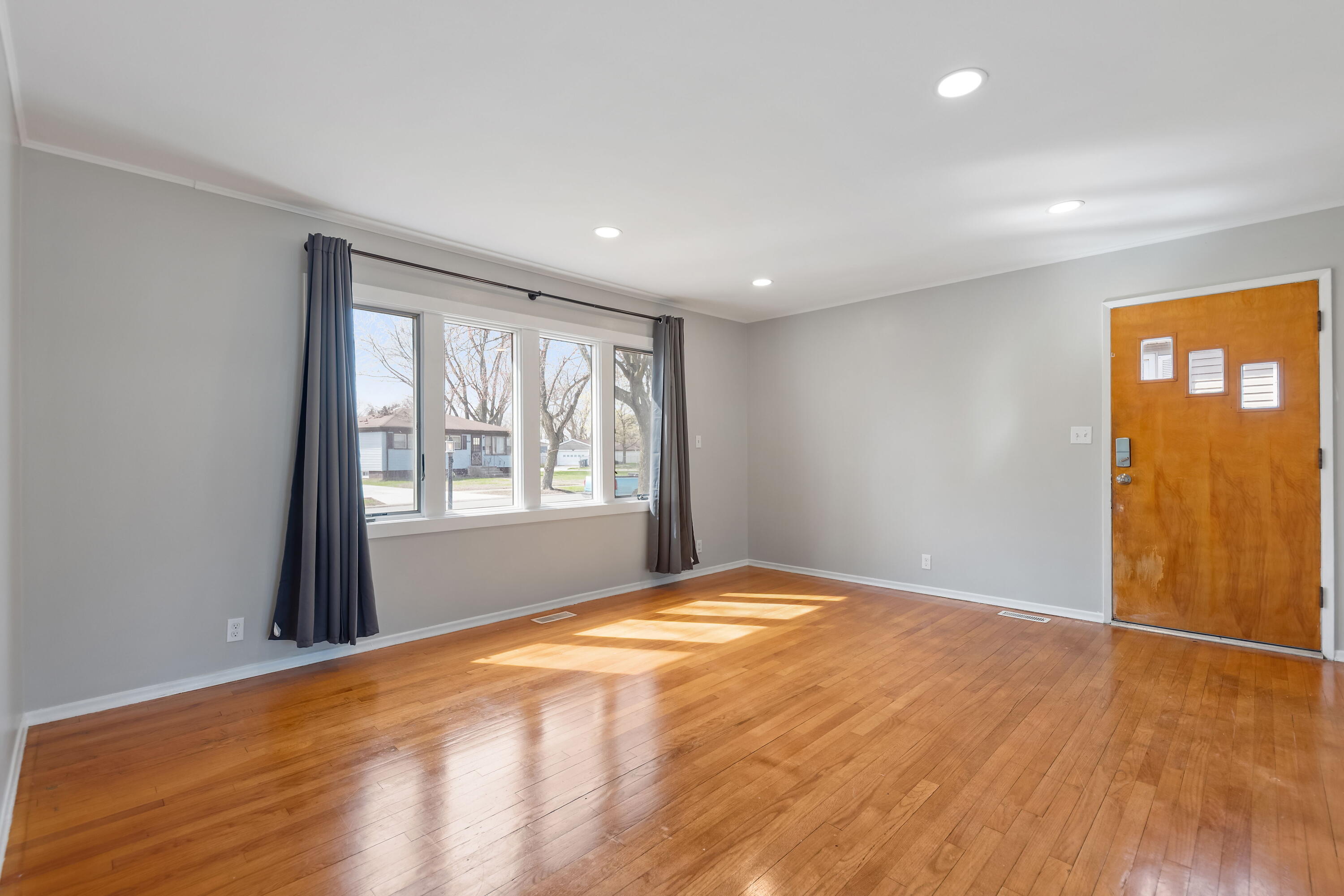 8143 Grace Street Highland, IN 46322 - Photo 4 of 18 a view of an empty room with wooden floor and a window
