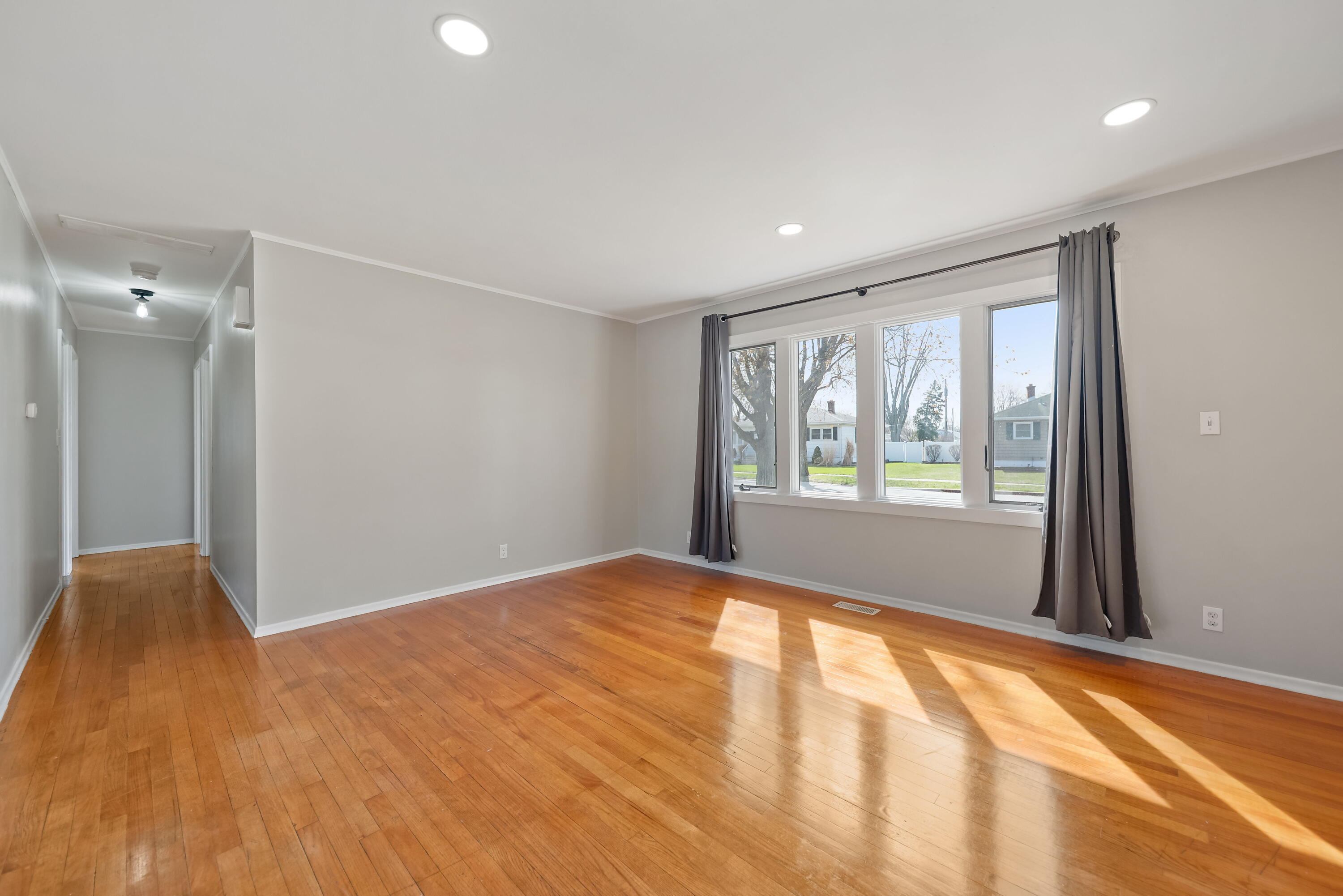 8143 Grace Street Highland, IN 46322 - Photo 6 of 18 a view of an empty room with wooden floor and a window