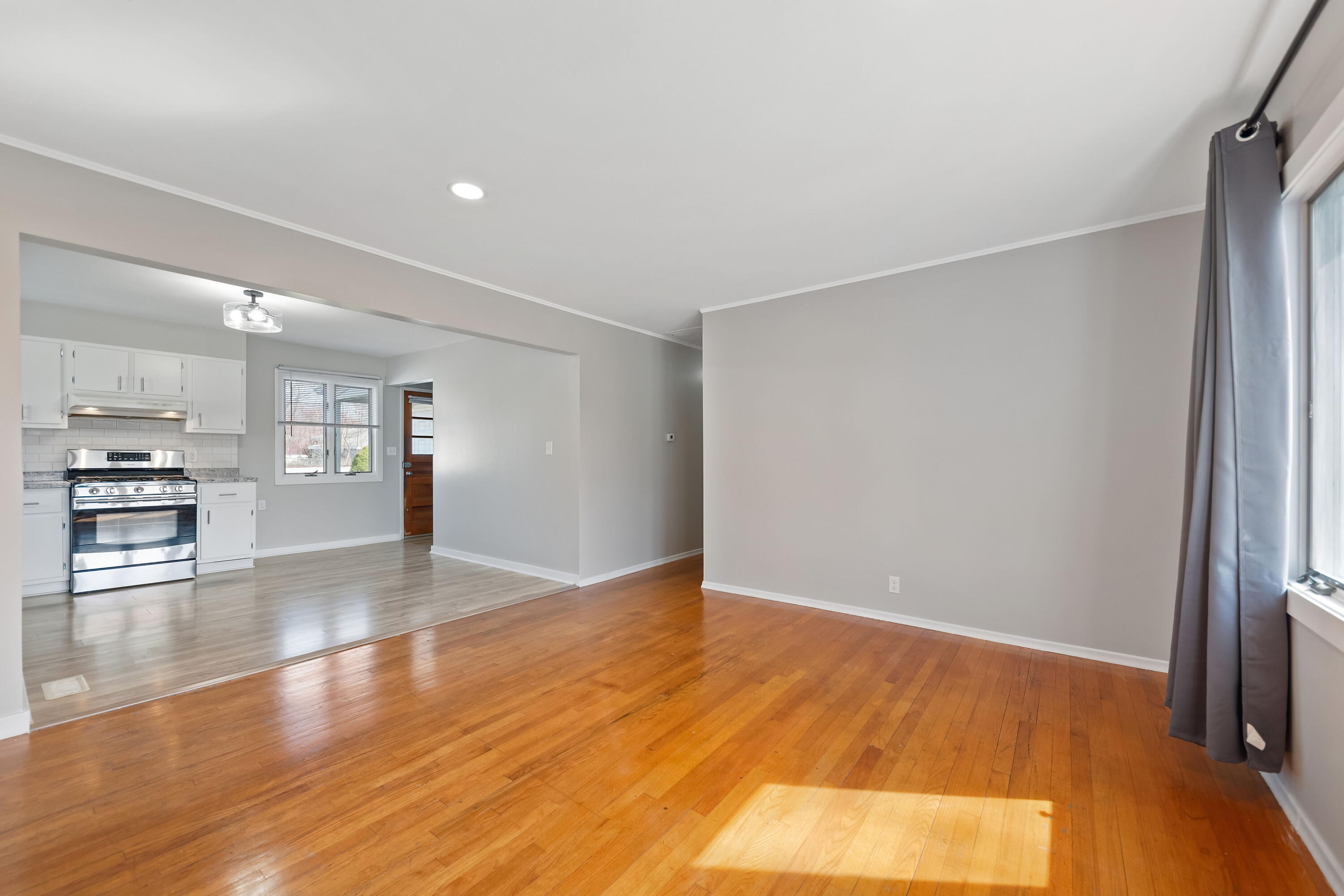 8143 Grace Street Highland, IN 46322 - Photo 8 of 18 a view of an empty room with wooden floor and a window