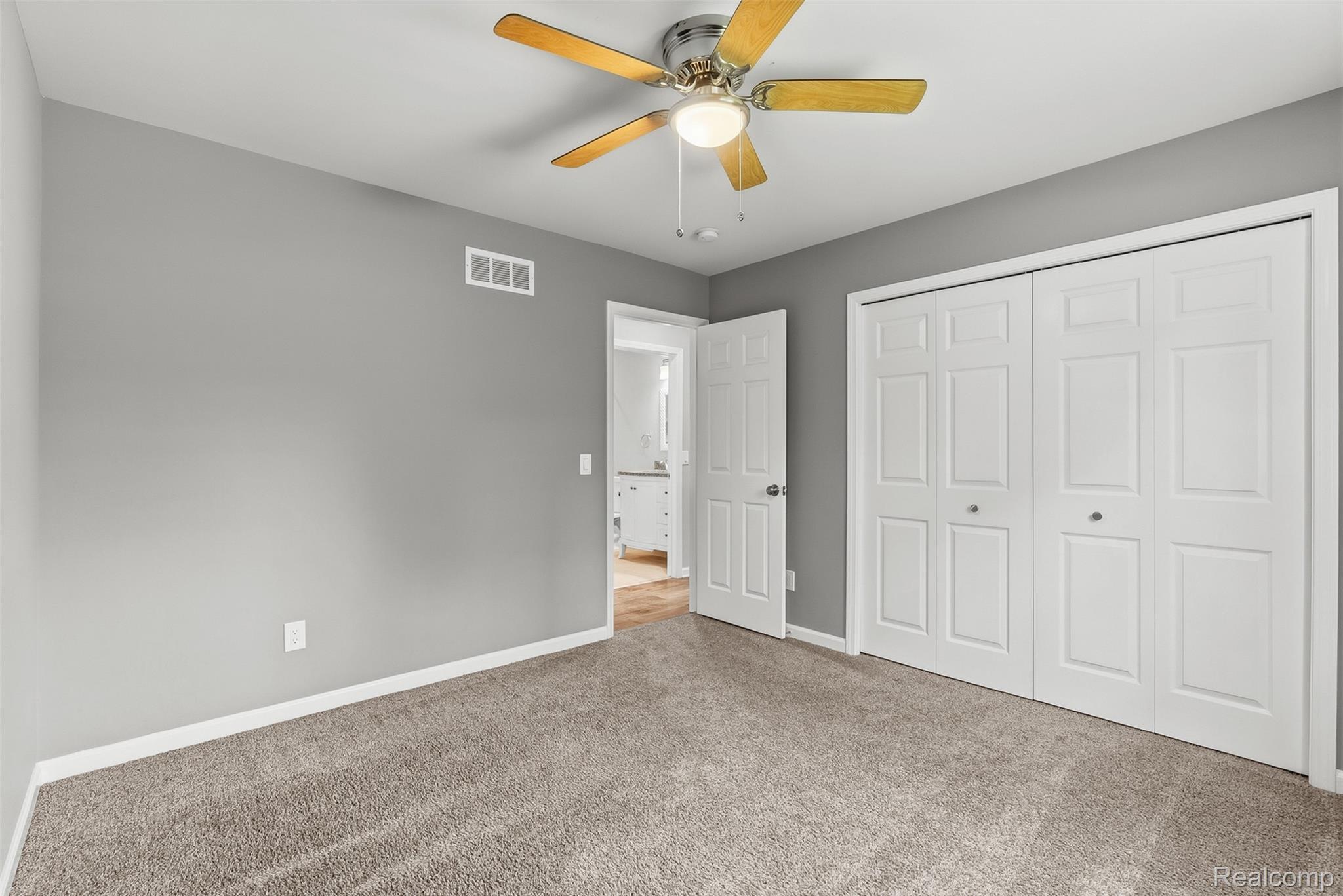 1750 Henbert Road West Bloomfield, MI 48324 - Photo 24 of 32 Neutral wall color, ceiling fan, bi-fold closet doors, and plush carpeting