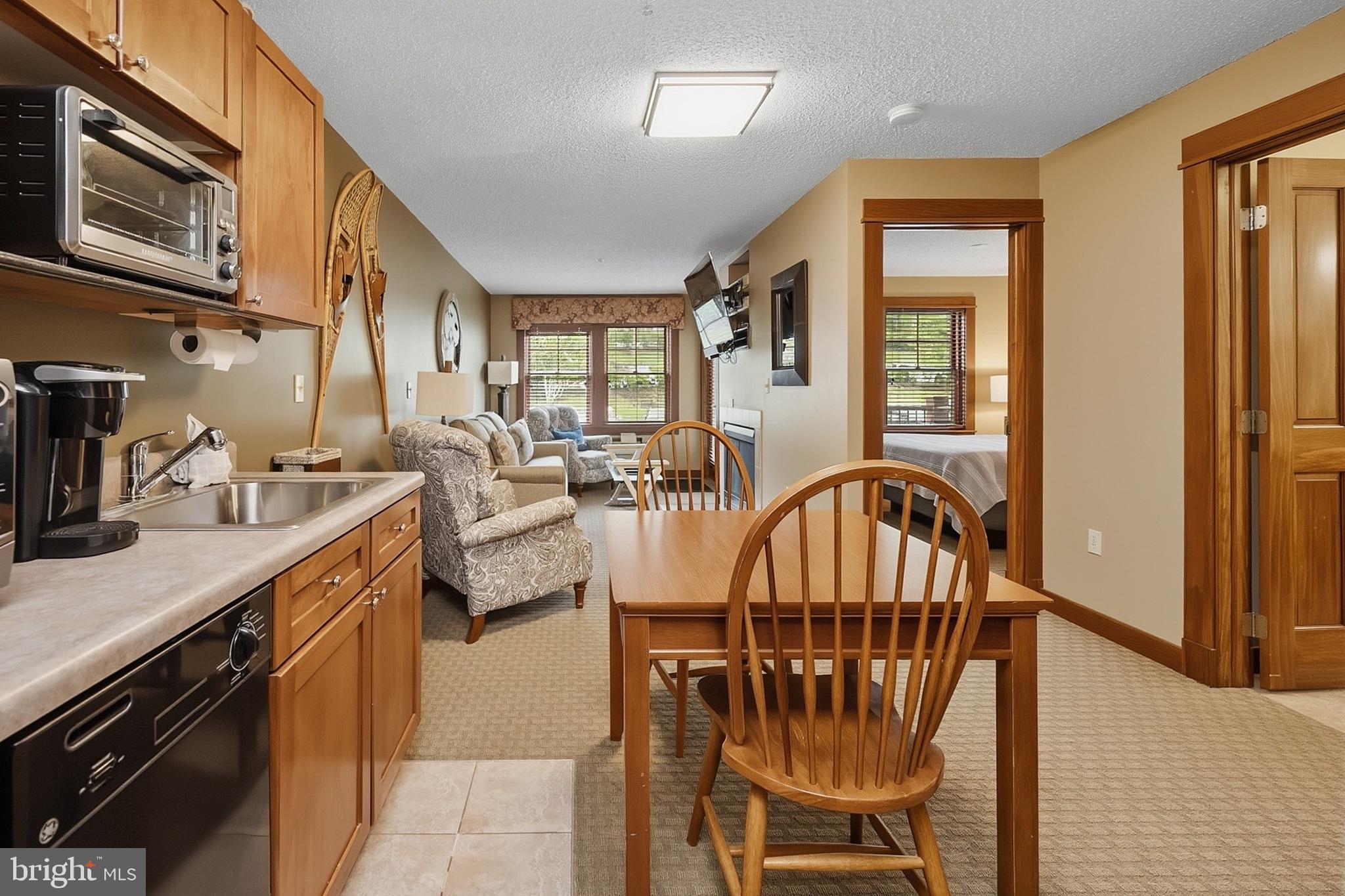 565 Glendale Road, Unit 208A Oakland, MD 21550 - Photo 7 of 51 a view of a kitchen with furniture a ceiling fan and a wooden floor