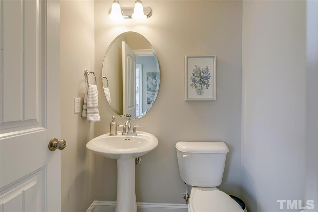 708 Fallon Grove Way Raleigh, NC 27608 - Photo 16 of 30 a bathroom with a toilet sink and mirror
