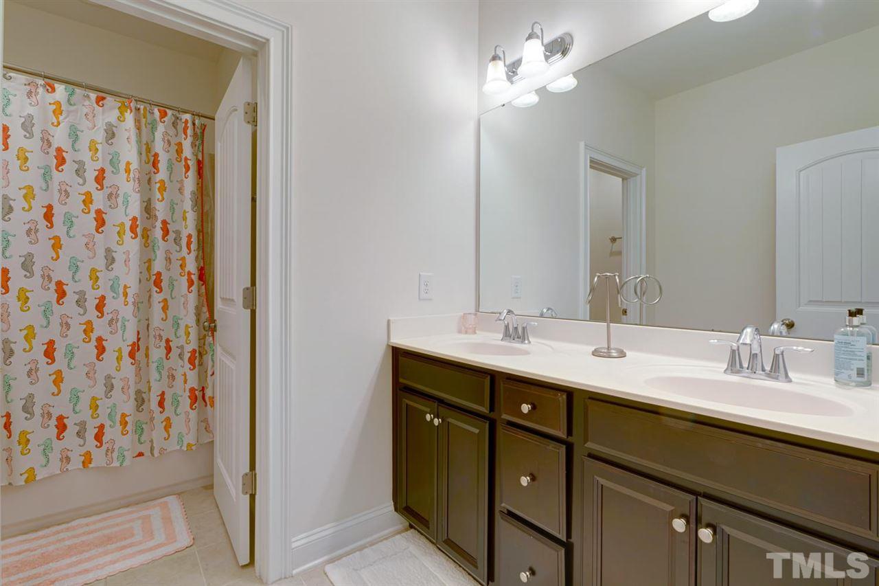 708 Fallon Grove Way Raleigh, NC 27608 - Photo 23 of 30 a bathroom with a double vanity sink and a mirror