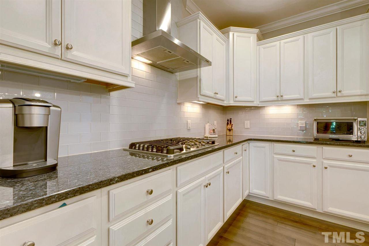 708 Fallon Grove Way Raleigh, NC 27608 - Photo 8 of 30 a kitchen with granite countertop white cabinets and stainless steel appliances