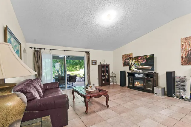 a living room with furniture a large window and a flat screen tv