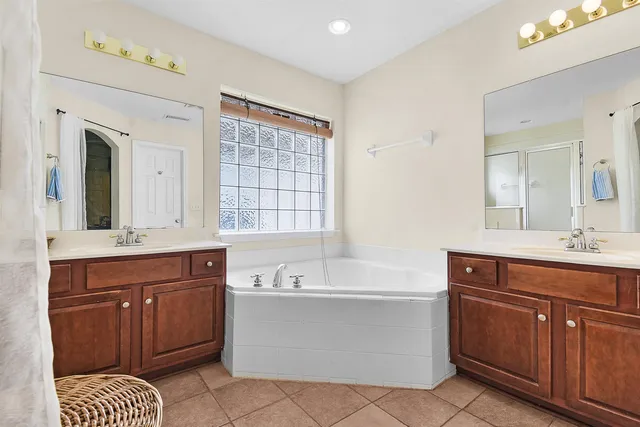 a spacious bathroom with a tub sink and mirror