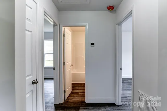 a view of a hallway with wooden floor and closet