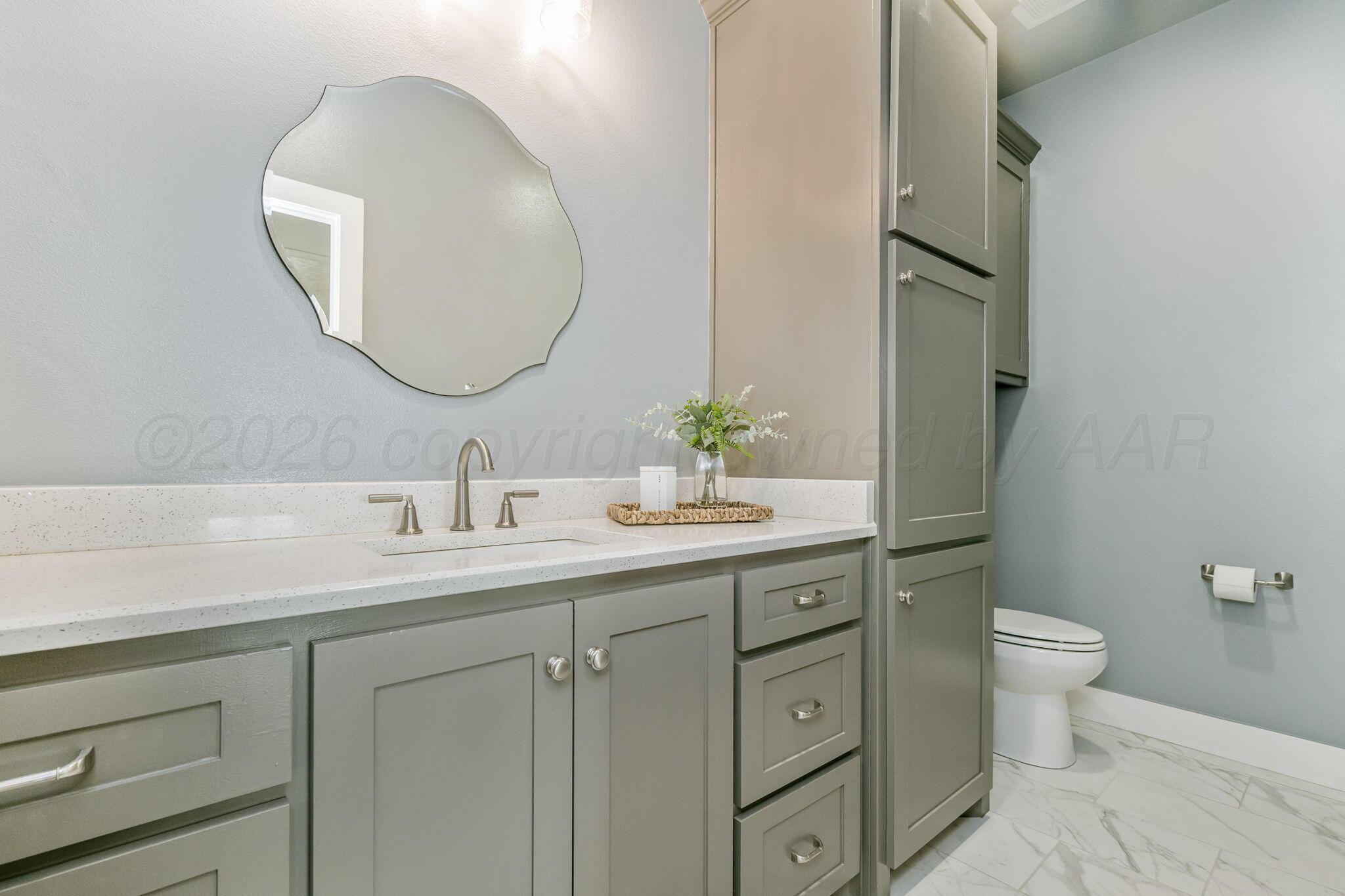 26150 Newton Road Canyon, TX 79015 - Photo 13 of 43 a bathroom with a toilet a sink and mirror