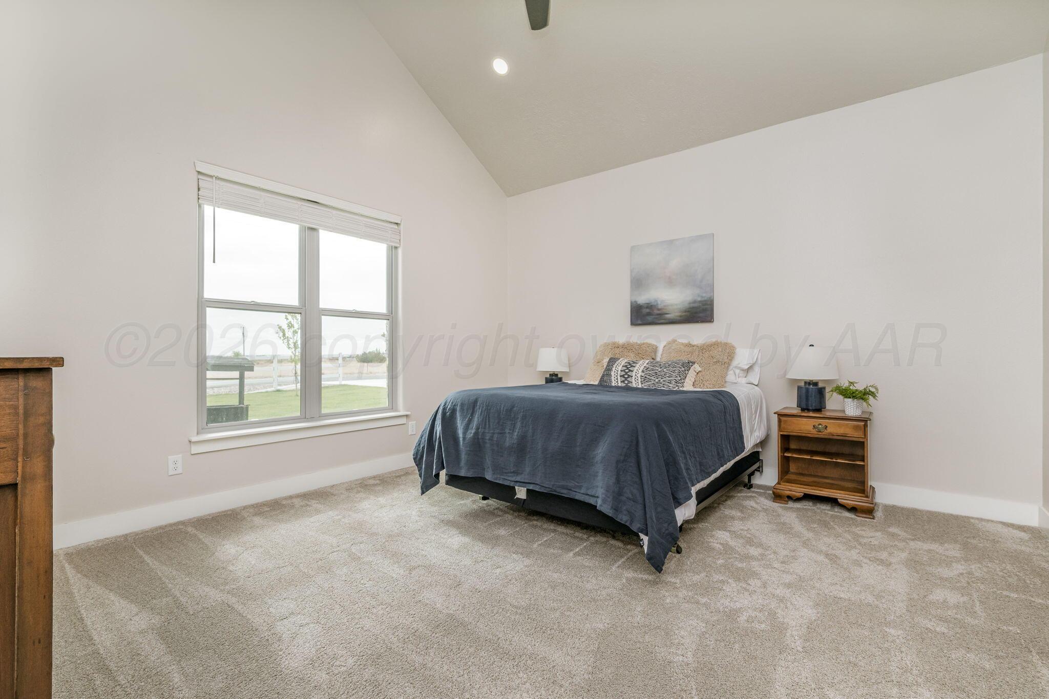 26150 Newton Road Canyon, TX 79015 - Photo 15 of 43 a spacious bedroom with a bed and a window