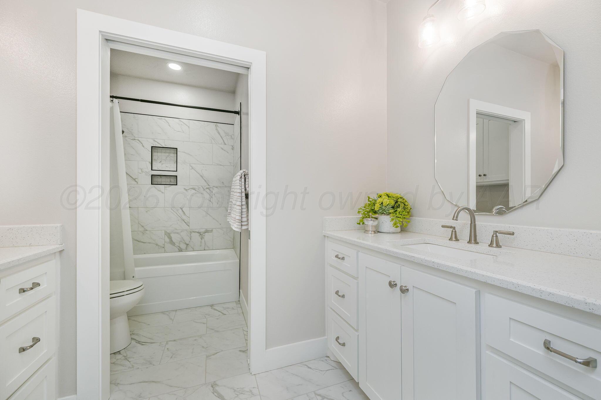 26150 Newton Road Canyon, TX 79015 - Photo 22 of 43 a bathroom with a granite countertop sink a mirror and a bathtub
