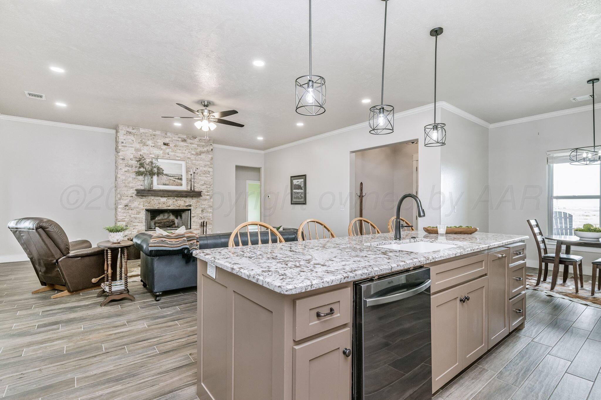 26150 Newton Road Canyon, TX 79015 - Photo 8 of 43 a kitchen with a stove a sink a dining table and chairs with wooden floor
