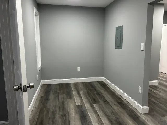 a view of a room with wooden floor and a window