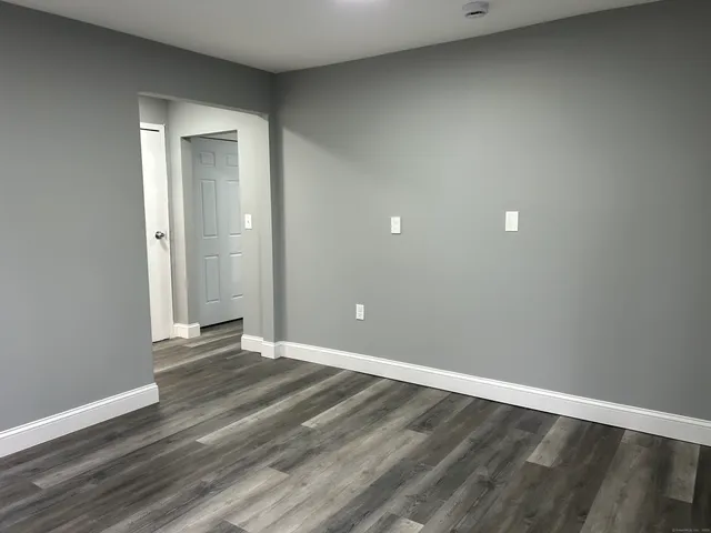 a view of an empty room with wooden floor