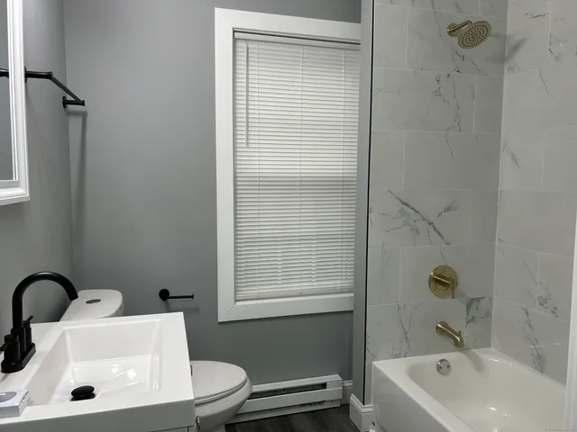 a bathroom with a sink a toilet and shower