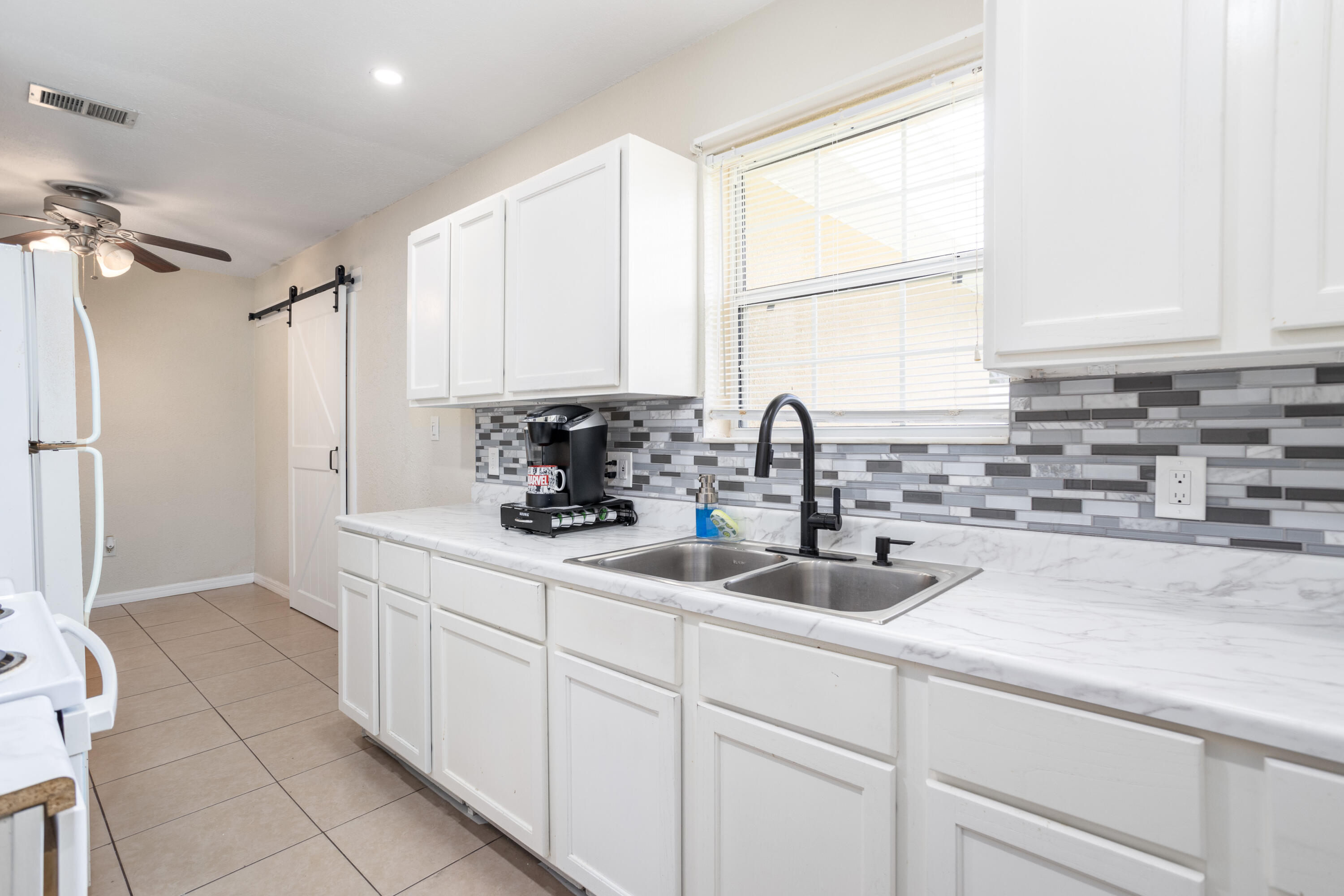 319 West Rutgers Street Melbourne, FL 32901 - Photo 5 of 19 a kitchen with sink a refrigerator and cabinets