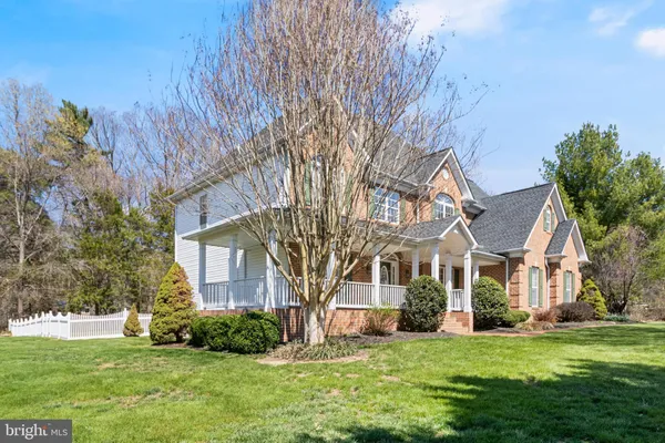 an aerial view of a house with a yard and a large tree
