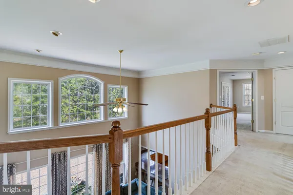 a view of a livingroom with a chandelier wooden floor and windows