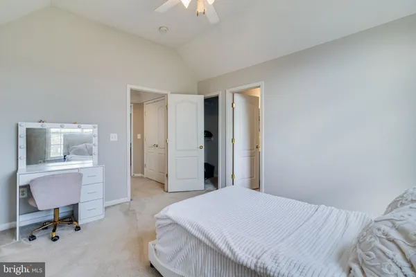a view of a livingroom with wooden floor a ceiling fan and windows