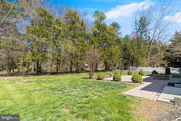 a view of a brick house with a big yard and large trees