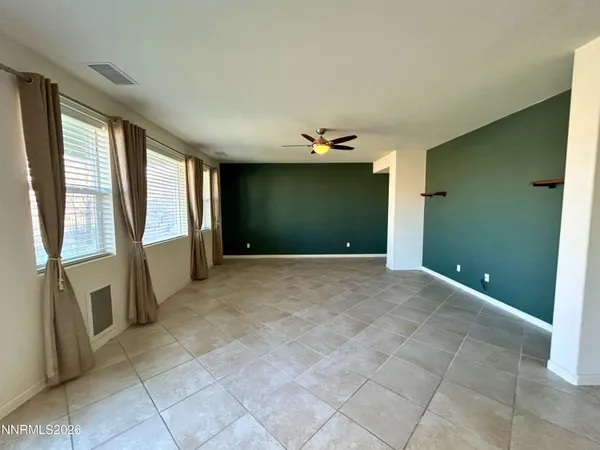 a view of a hallway with the couches and kitchen view