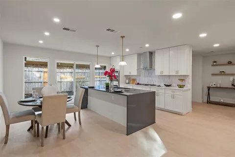a view of a kitchen with kitchen island stainless steel appliances a sink stove and cabinets