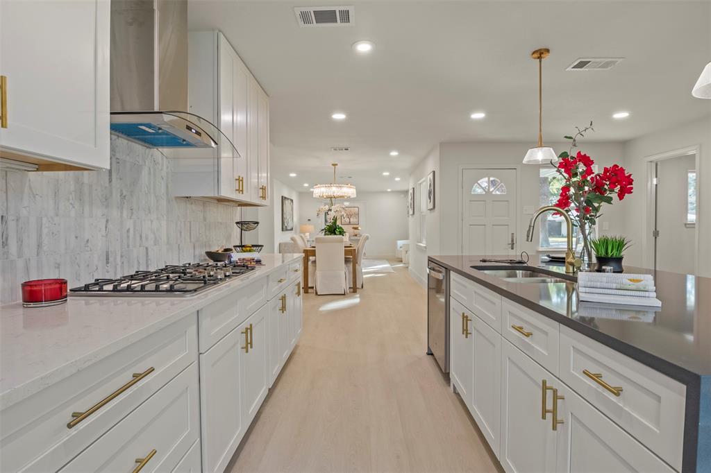 10427 Carry Back Place Dallas, TX 75229 - Photo 15 of 40 a view of a kitchen with kitchen island stainless steel appliances a sink stove and cabinets