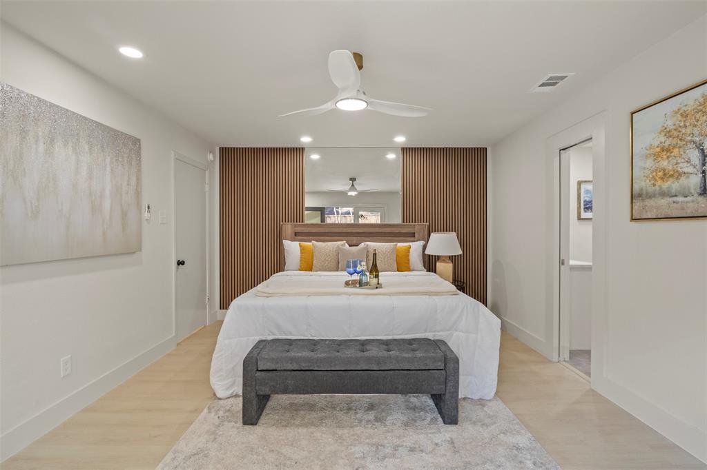 10427 Carry Back Place Dallas, TX 75229 - Photo 21 of 40 a spacious bedroom with a bed and a painting