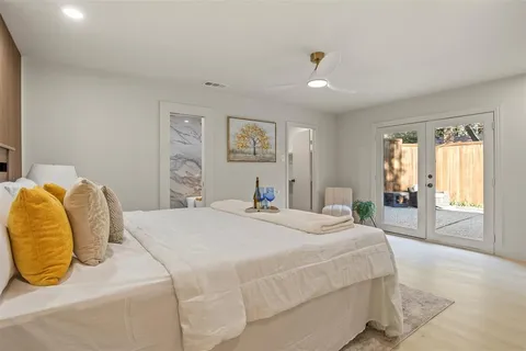 a spacious bedroom with a bed and glass window