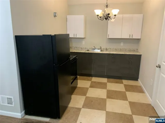 a kitchen with a sink a cabinetry and refrigerator