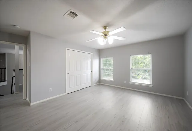 an empty room with wooden floor and window