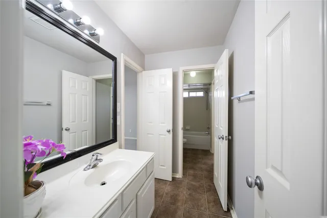 a bathroom with a sink vanity mirror and shower