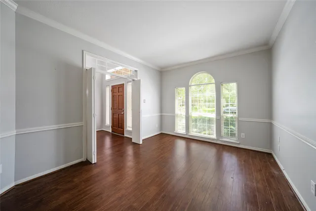 an empty room with wooden floor and a window