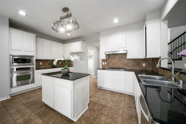 a kitchen with stainless steel appliances granite countertop a stove and a sink