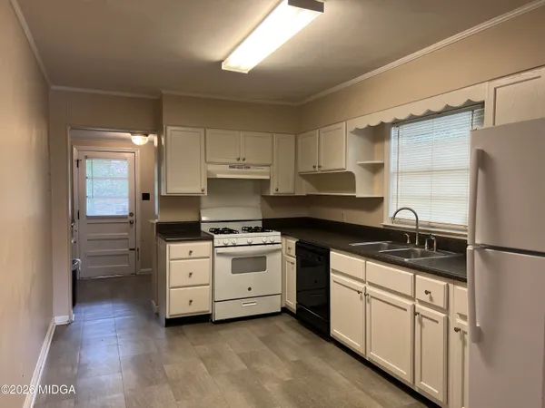 a kitchen with white cabinets and white appliances