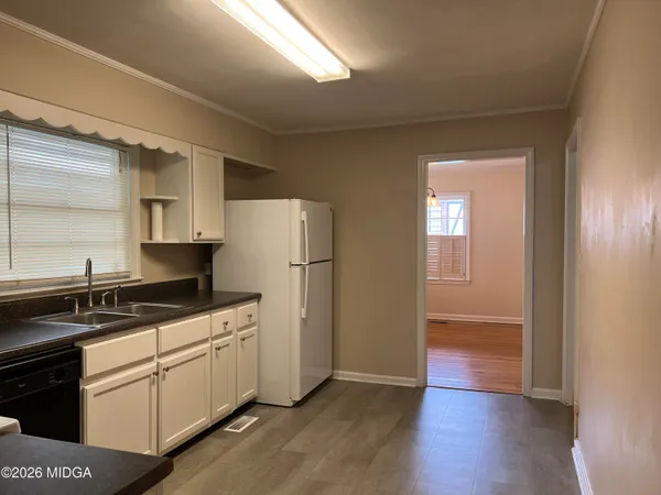a kitchen with a sink a refrigerator and cabinets