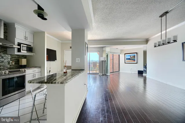 a kitchen with granite countertop a stove and a wooden floors