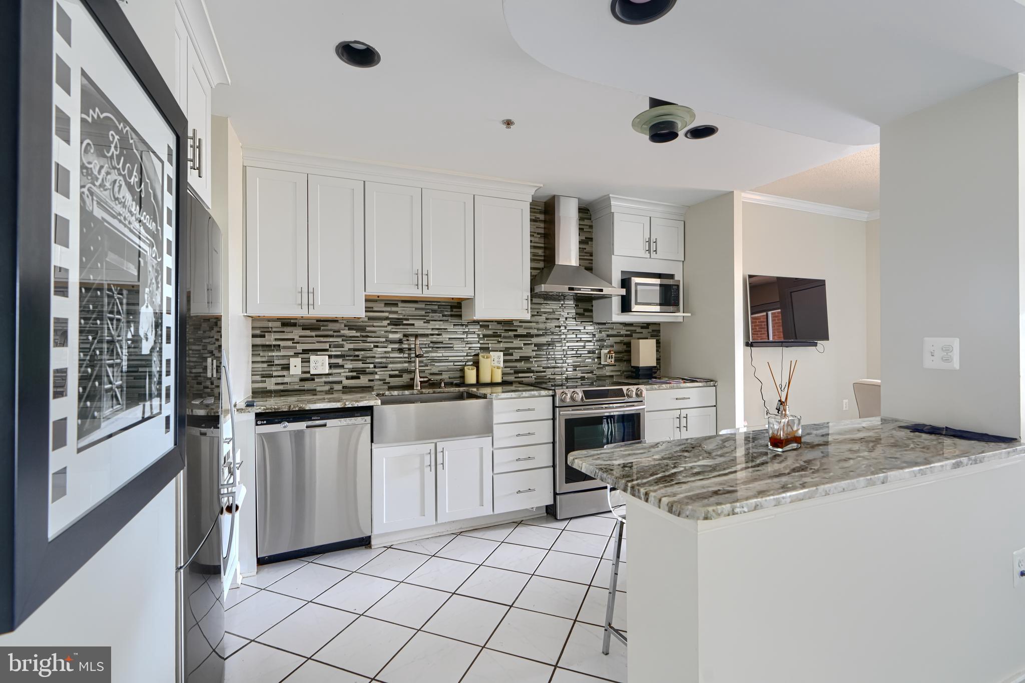 2515 Boston Street, Unit 706 Baltimore, MD 21224 - Photo 3 of 21 a kitchen with stainless steel appliances granite countertop a stove a sink and a refrigerator