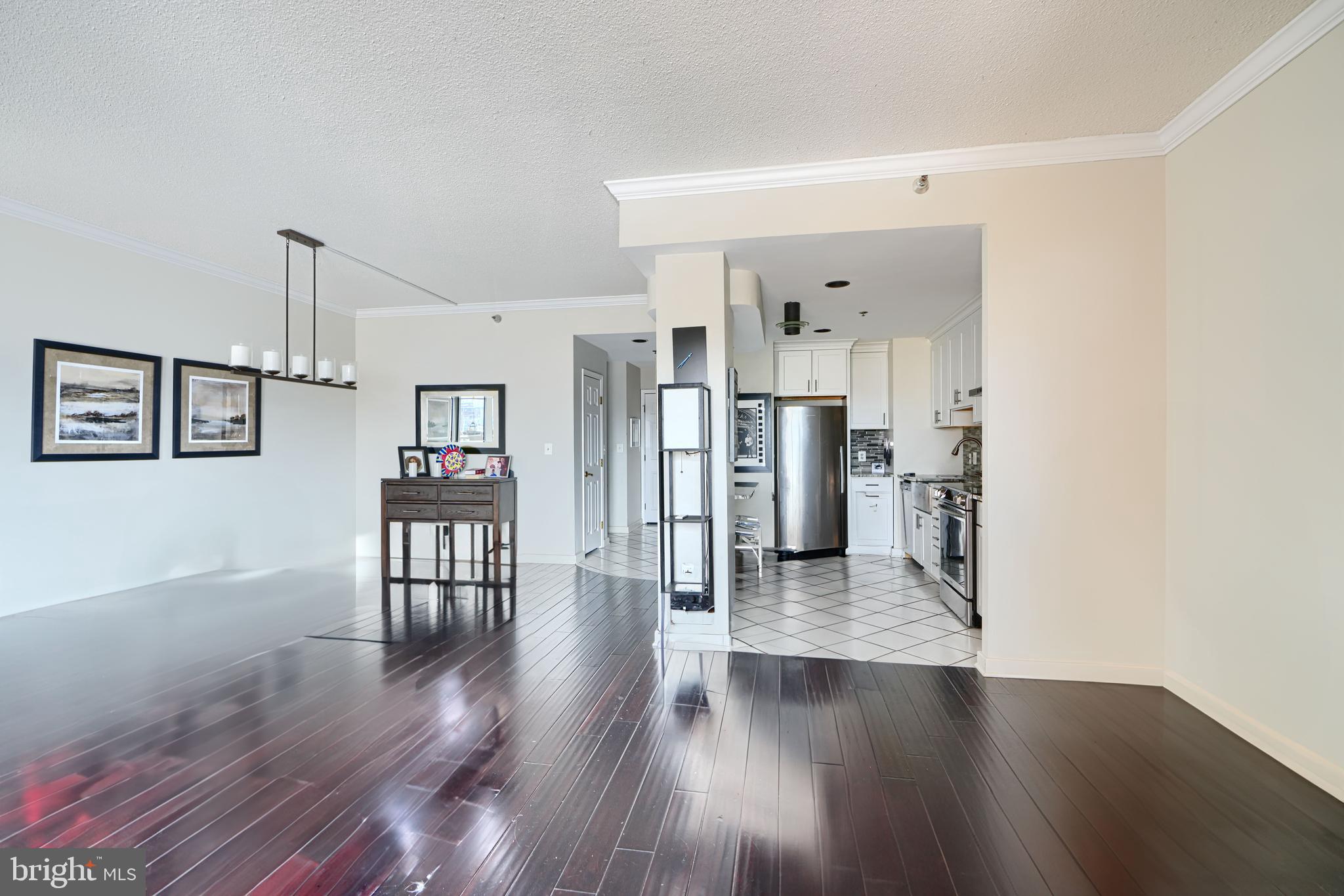 2515 Boston Street, Unit 706 Baltimore, MD 21224 - Photo 5 of 21 a hallway with wooden floor table and chairs