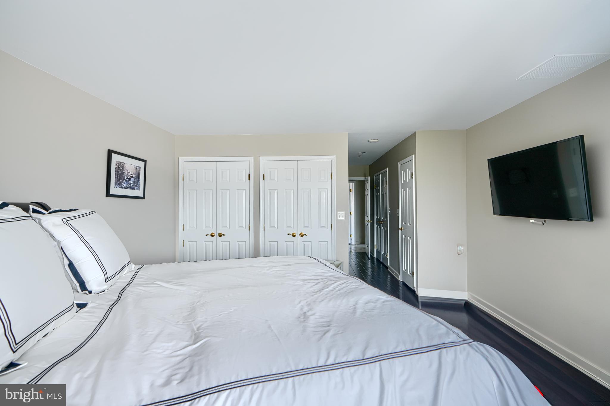 2515 Boston Street, Unit 706 Baltimore, MD 21224 - Photo 7 of 21 a bedroom with a bed and a flat screen tv