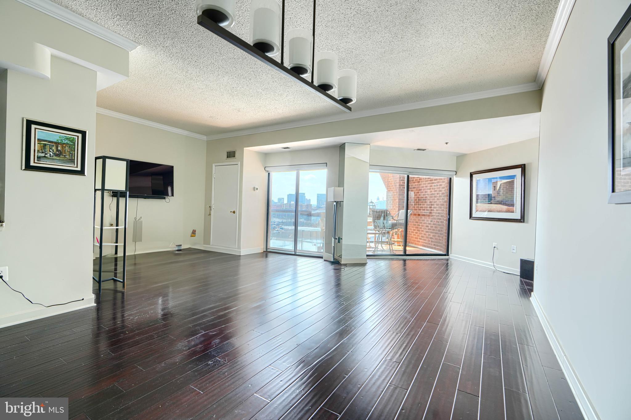 2515 Boston Street, Unit 706 Baltimore, MD 21224 - Photo 9 of 21 a view of an empty room with wooden floor and a window