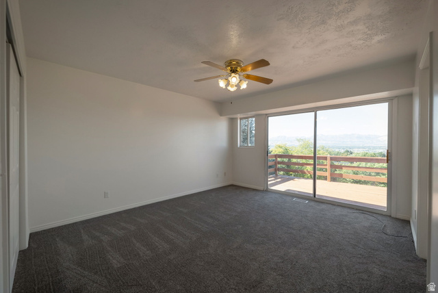 11922 Bluff View Drive Sandy, UT 84092 - Photo 14 of 30 Spare room featuring dark colored carpet, ceiling fan, and a textured ceiling