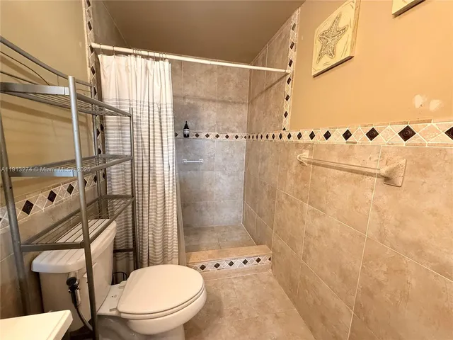 a bathroom with a toilet and a shower