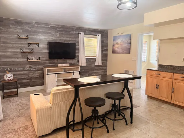 a view of a dining room with furniture and a flat screen tv