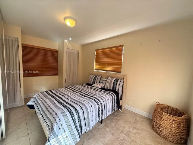 a bedroom with a bed and painting on the wall