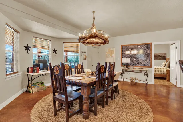 a dining room with wooden floor a chandelier a wooden table and chairs