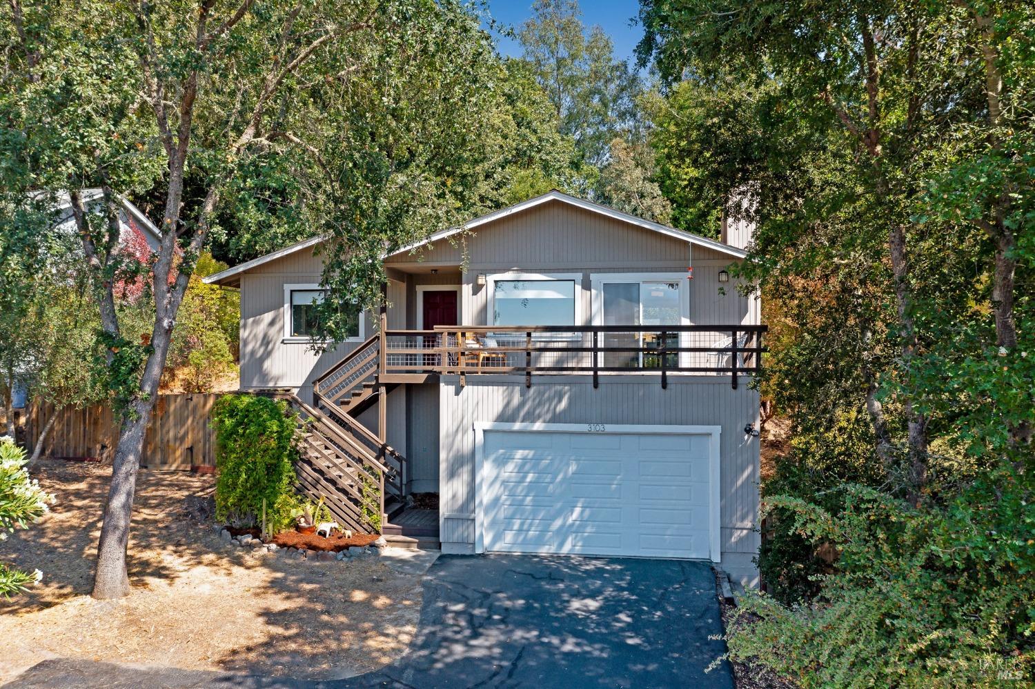 a view of a house with a yard and large tree