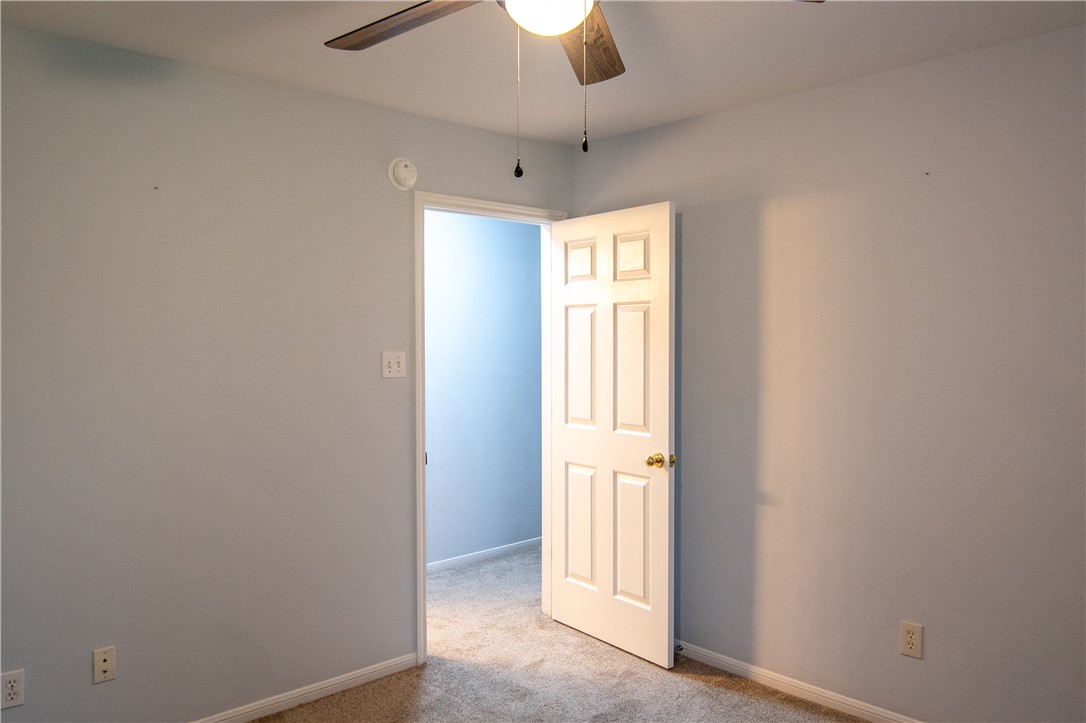 1735 Rock Hollow Loop Bryan, TX 77807 - Photo 17 of 25 an empty room with a hallway and a chandelier fan