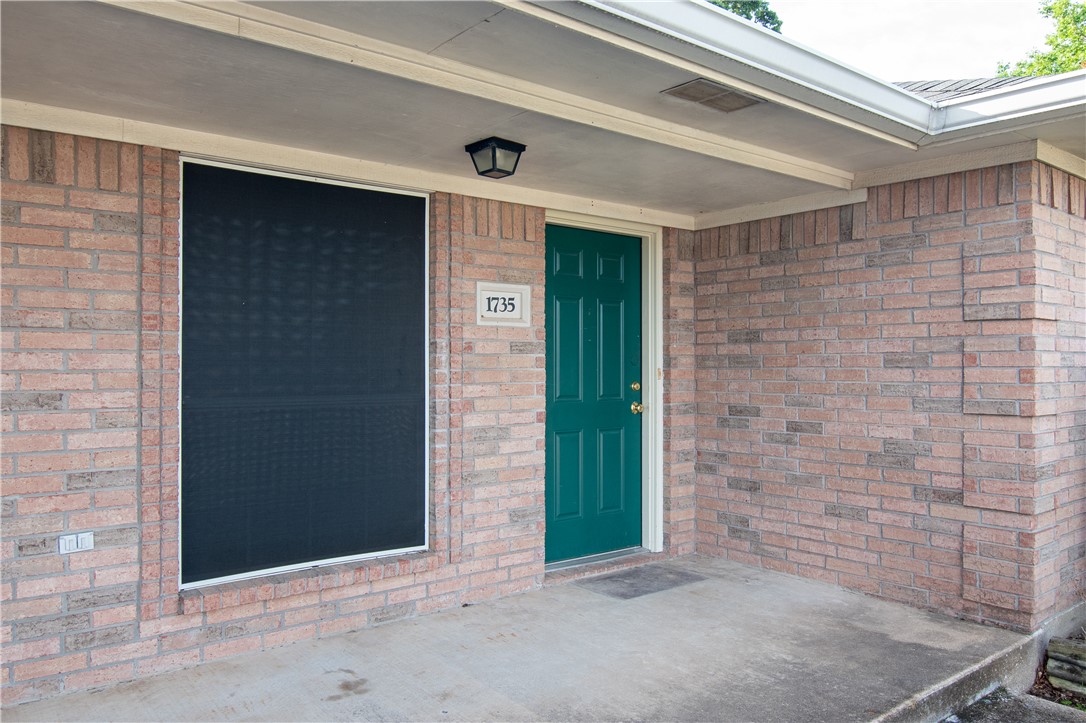 1735 Rock Hollow Loop Bryan, TX 77807 - Photo 2 of 25 a brick house with a large door