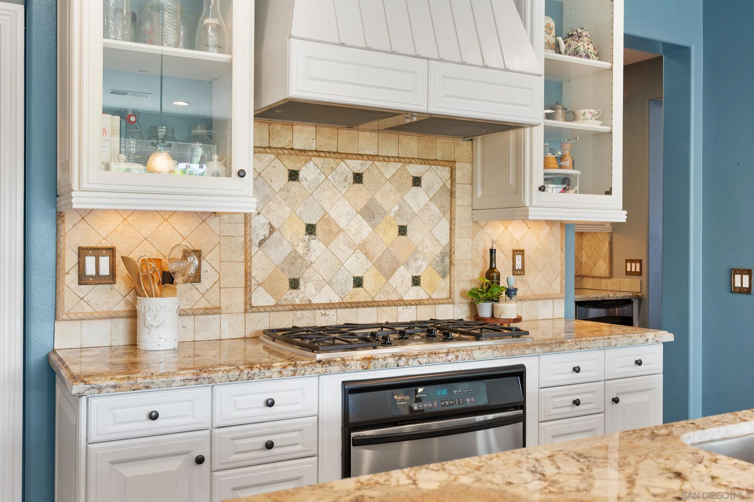 15976 Cayenne Ridge Road San Diego, CA 92127 - Photo 10 of 32 a kitchen with granite countertop a stove and cabinets